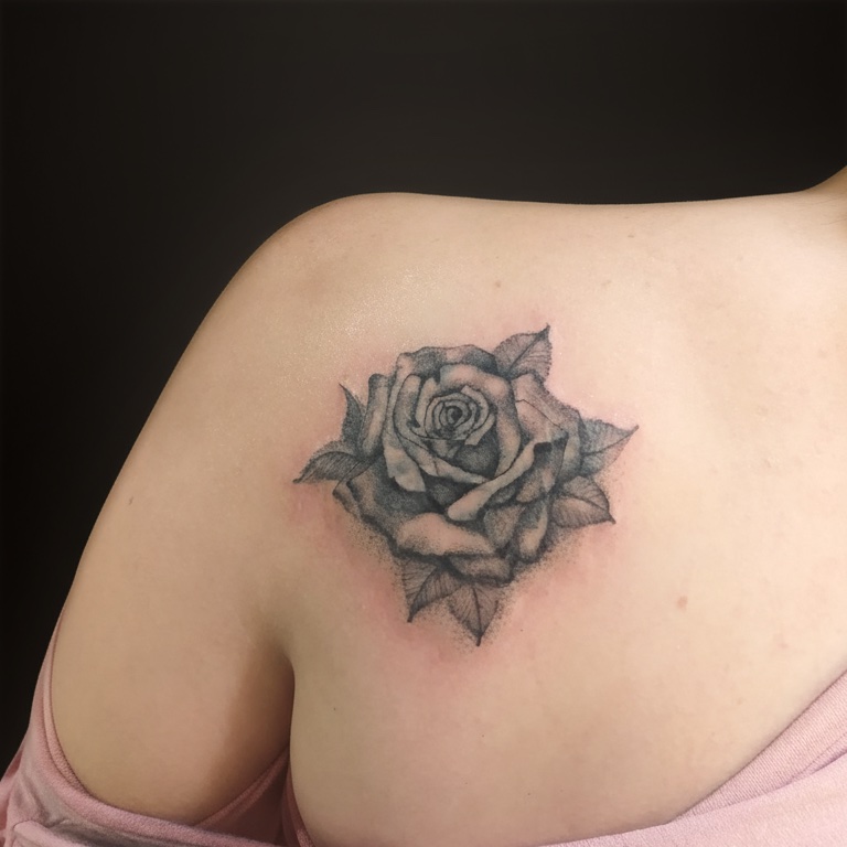 Tatuagem feminina delicada de rosa em realismo no ombro, feita pelo tatuador feminino em Mogi das Cruzes e região.