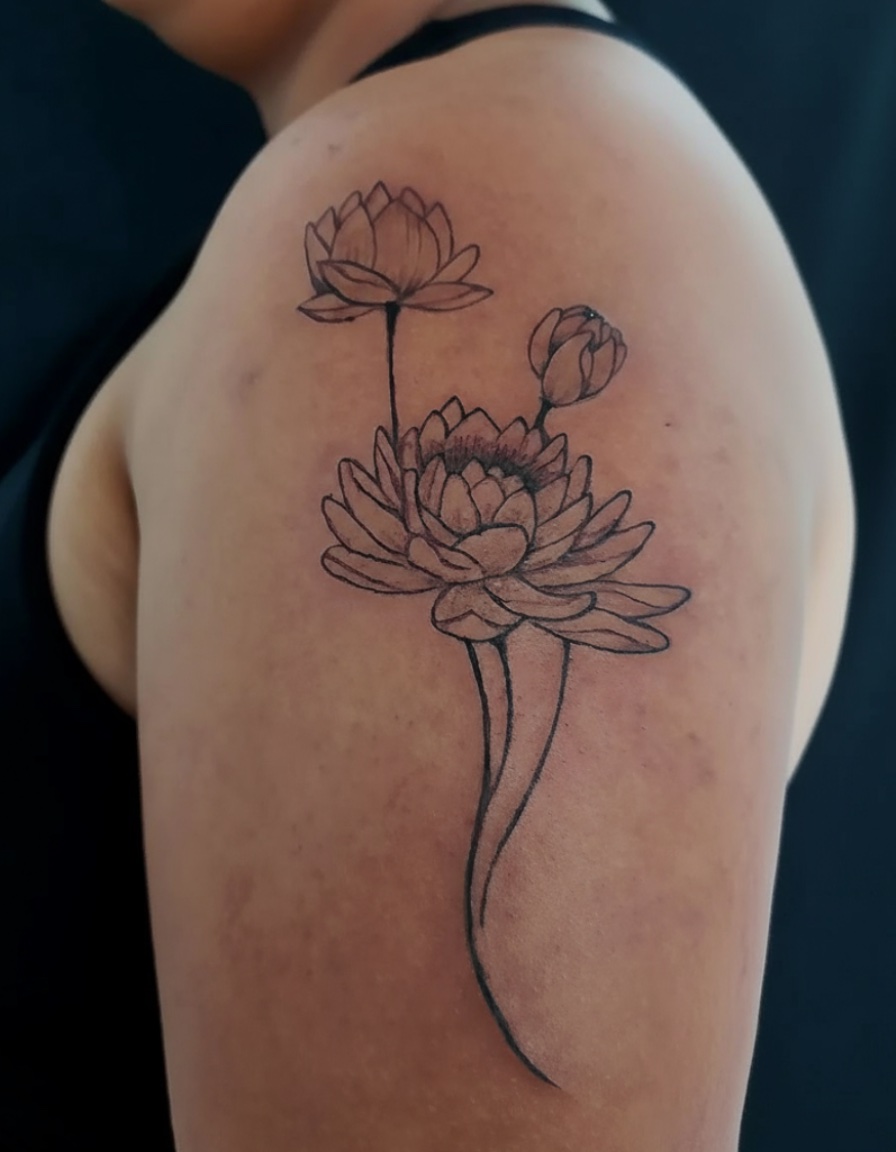 Tatuagem feminina no braço de flor de lótus, estilo delicado e minimalist. Tattoo feminina no braço feita pelo tatuador feminino Cris Santos em Mogi das Cruzes e região.